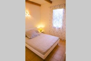 Locations l'Inzecca في جيزنوكسيا: غرفة نوم صغيرة بها سرير ونافذة