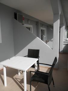 einen weißen Tisch und zwei Stühle in einem Zimmer in der Unterkunft Apartments Babić in Novalja