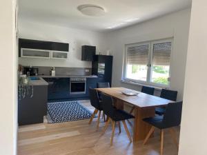 a kitchen and dining room with a wooden table and chairs at Apartment mit Parkblick in Gratkorn