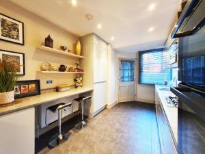 cocina con encimera y taburetes en St Paul's Studios apartment en Londres