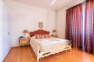 a bedroom with a bed and a window with curtains at Archontiko Petrettini Boutique Hotel in Corfu