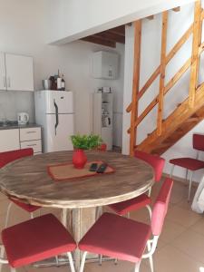 a kitchen with a wooden table and red chairs at Hermosa Casita Paso Patria in Paso de la Patria