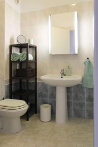 a bathroom with a sink and a toilet and a mirror at Penthouse Alentejana in Vila Nova de Milfontes