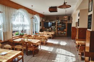 a restaurant with wooden tables and wooden chairs at Motel Tošanovice in Dolní Tošanovice