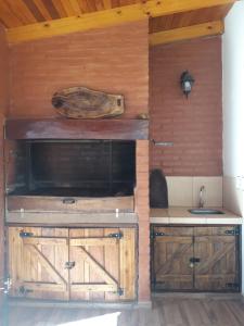 een keuken met houten kasten en een wastafel bij Hermosa Casita Paso Patria in Paso de la Patria