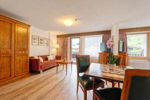 - un salon avec une table, des chaises et un canapé dans l'établissement Hotel Arca Solebad & Spa, à Zermatt
