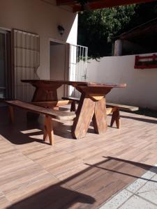 een houten picknicktafel en bank op een patio bij Hermosa Casita Paso Patria in Paso de la Patria