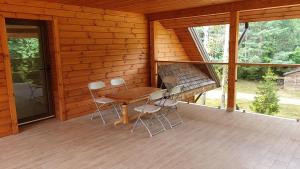 PanaraにあるPilnų namų bendruomenės apartamentaiの木造キャビン(テーブル、椅子付)
