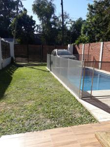een tuin met een hek en een zwembad bij Hermosa Casita Paso Patria in Paso de la Patria