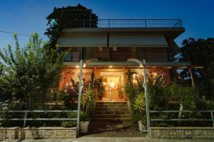 a house with a staircase leading to the front door at Hotel Loula Rooms and Apartments in Kamena Vourla