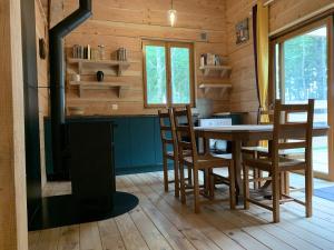 une salle à manger avec une cheminée, une table et des chaises dans l'établissement Les Cabanes de Lou-loup écologiques et autonomes, à Anzème 26 autres photos