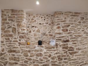 a room with a stone wall with a vase on it at Le segrete in Sannicandro di Bari