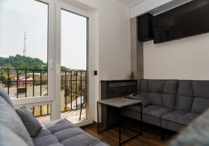 ein Wohnzimmer mit einem Sofa und einem großen Fenster in der Unterkunft VIP apartment- Розумний дім in Lwiw