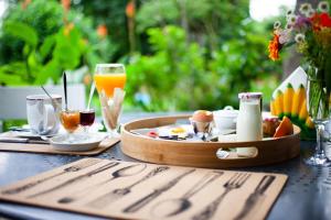 a table with a tray of food and glasses of orange juice at Mirguet au Jardin in Saint-Élix-le-Château