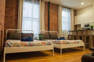 two beds in a room with a brick wall at Studios in New York in New York