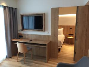 a room with a television and a bed at Muralto Madrid Princesa in Madrid