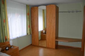 阿爾高地區旺根的住宿－Ferienwohnung Kitzelmann，一间带镜子和木制衣柜的卧室