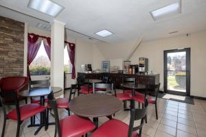 a dining room with tables and red chairs at Red Roof Inn Warrenton in Warrenton