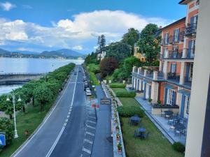 a view of a city street with buildings and the water at liberty lake house in Stresa