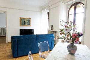 uma sala de estar com um sofá azul e um vaso de flores em liberty lake house em Stresa