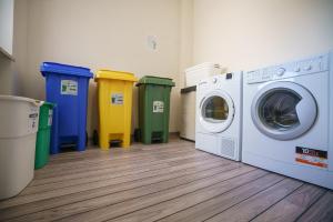 a laundry room with washing machines and trash cans at Atmosphera in Galatina