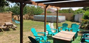 eine Gruppe blauer Stühle, ein Tisch und ein Pool in der Unterkunft Location saisonnière in Coursan