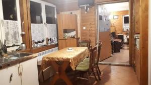 uma cozinha com uma mesa e algumas cadeiras e um quarto em Łemkowo Pokoje Gościnne em Lutowiska