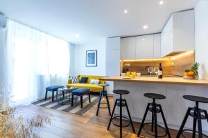 a kitchen with bar stools and a yellow couch at Old platz apartment in Split