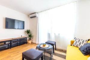 a living room with a yellow couch and a tv at Old platz apartment in Split