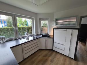 a kitchen with a white refrigerator and two windows at Große Ferienwohnung Nähe Flughafen Köln Bonn in Troisdorf