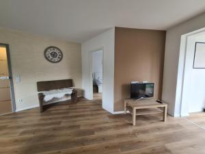 a living room with a tv and a table at Große Ferienwohnung Nähe Flughafen Köln Bonn in Troisdorf