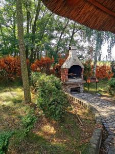 an outdoor brick oven in a garden with trees at Domek na wsi nad jeziorem , prywatny staw in Kamieńczyk Dezerta