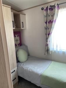 ein kleines Schlafzimmer mit einem Bett und einem Fenster in der Unterkunft Casa Cabana in Lincoln
