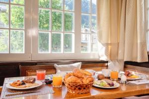 una mesa cubierta con platos de comida y zumo de naranja en Naco Aparthotel by Arca Spa, en Zermatt
