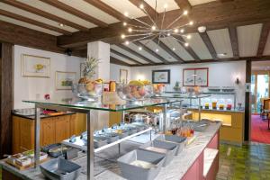 a restaurant with a counter with bowls of food at Naco Aparthotel by Arca Spa in Zermatt