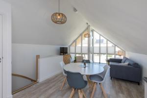 a dining room with a white table and chairs at Vakantiehuis Domburg, met sauna in Domburg