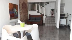 - un salon avec une table et des chaises ainsi qu'un escalier dans l'établissement Hospedagem Lirio, à Bragança Paulista