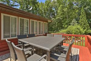a patio with a table and chairs on a deck at Pocono Mountains Cabin with Patio, Near Hiking! in East Stroudsburg