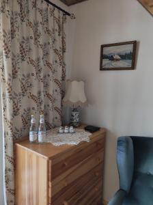 a room with a dresser with a lamp and a curtain at Domek dla dwojga in Tylicz