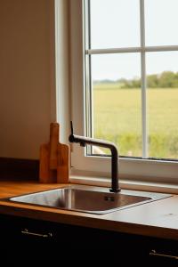 a kitchen sink with a window with a view of a field at Hof Babel in Domburg