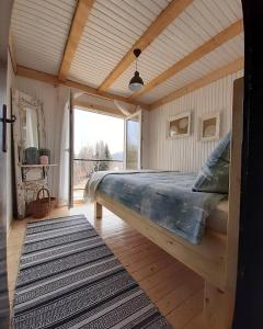a bedroom with a bed and a large window at Forest Hill kuća za odmor na Zlataru in Nova Varoš