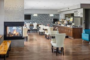 a restaurant with a fireplace and tables and chairs at Home Inn & Suites Yorkton in Yorkton