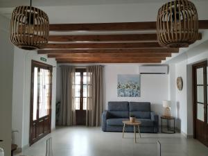 ein Wohnzimmer mit einem blauen Sofa und 2 Kronleuchtern in der Unterkunft Hotel El Molino in Osuna
