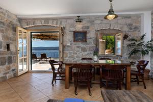 a dining room with a stone wall and a table and chairs at Villa Lucija in Mimice