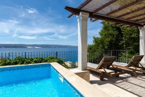 a swimming pool with two chairs and a gazebo at Villa Lucija in Mimice