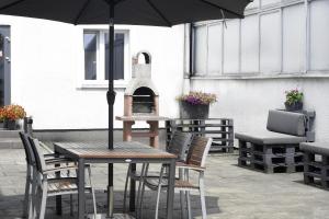a table and chairs with an umbrella on a patio at Hostel Helios in Września