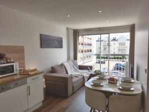 sala de estar con sofá y mesa con sillas en Appart'HomeCity - Rouen Ile Lacroix Seine en Rouen