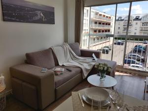 a living room with a couch and a table at Appart'HomeCity - Rouen Ile Lacroix Seine in Rouen