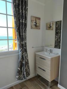 La salle de bains est pourvue d'un lavabo et d'une fenêtre. dans l'établissement Au gré des marées, appartement face à la mer, classé 3 étoiles, à Ault