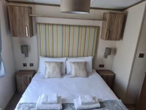 una camera da letto con un letto bianco con due asciugamani di Mawgan Pads Trevella Crantock a Crantock